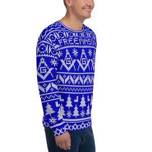 May include: A blue and white long-sleeved sweater with a Christmas-style pattern featuring snowflakes, trees, and the words "FREEMASON".