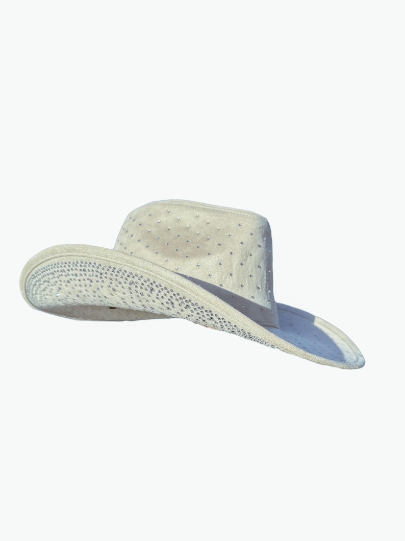 K&ouml;nnte beinhalten: Ein wei&szlig;er Cowboyhut mit einem mit Strasssteinen verzierten Hutband.