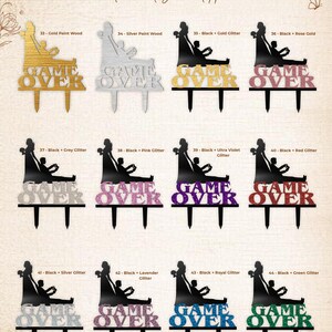 May include: A collection of twelve custom cake toppers labeled Forest Wedding Party, each featuring a silhouette of a couple playing video games above the text GAME OVER. The toppers are available in various finishes including gold, silver, and glitter.