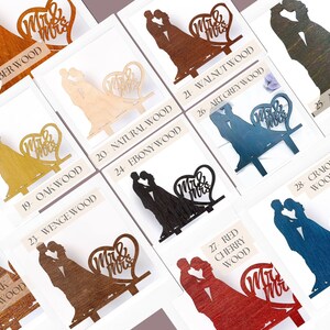 May include: A collection of wooden cake toppers featuring a silhouette of a couple kissing next to a heart shape with the text Mr & Mrs. The toppers are available in various finishes including amber, walnut, anthracite, natural, oak, ebony, wenge, red cherry, and craiola wood.