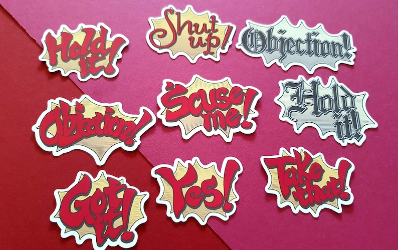 May include: Nine colorful speech bubble stickers with various phrases, including "Hold It!" "Shut Up!" "Objection!" "Save Me!" "Hold It!" "Take That!" "Objection!" "Got It!" and "Yes!" The stickers are on a red and white background.