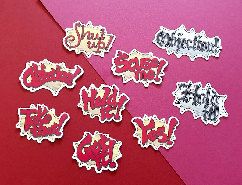 May include: Nine colorful speech bubble stickers with various phrases, including "Shut up!" "Objection!" "Hold it!" "Take that!" "Got it!" "Yes!" "Sauce me!" "Hold it!" and "Objection!"