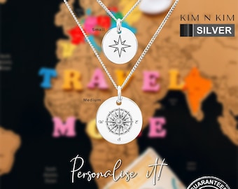 May include: Two silver necklaces featuring round pendants. The smaller pendant displays a simple four-pointed star, while the larger medium pendant features a detailed compass rose design with cardinal directions. Text includes KIM N KIM SILVER.