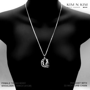 Puede incluir: Un collar con colgante de plata exhibido en un maniqu&iacute; negro. El colgante presenta un dise&ntilde;o detallado dentro de una forma de media luna. El collar tiene una cadena de bordillo de 56 cm. El ancho de los hombros del maniqu&iacute; es de 41 cm.