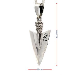 May include: A silver arrowhead pendant featuring a textured rope-style bail and engraved runic characters on the blade. The pendant measures 39.9mm in height and 19mm in width, as indicated by the red measurement lines visible in the image.