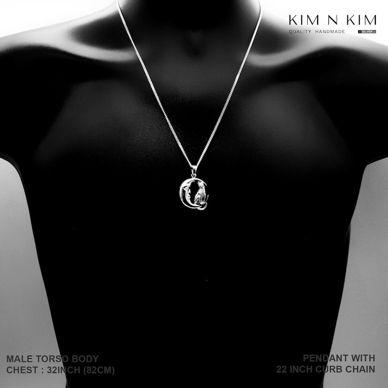 Puede incluir: Collar con colgante de plata con cadena de 56 cm. El colgante presenta un dise&ntilde;o de gato dentro de un marco circular. El maniqu&iacute; tiene un contorno de pecho de 82 cm. Se ve la marca "KIM N KIM".
