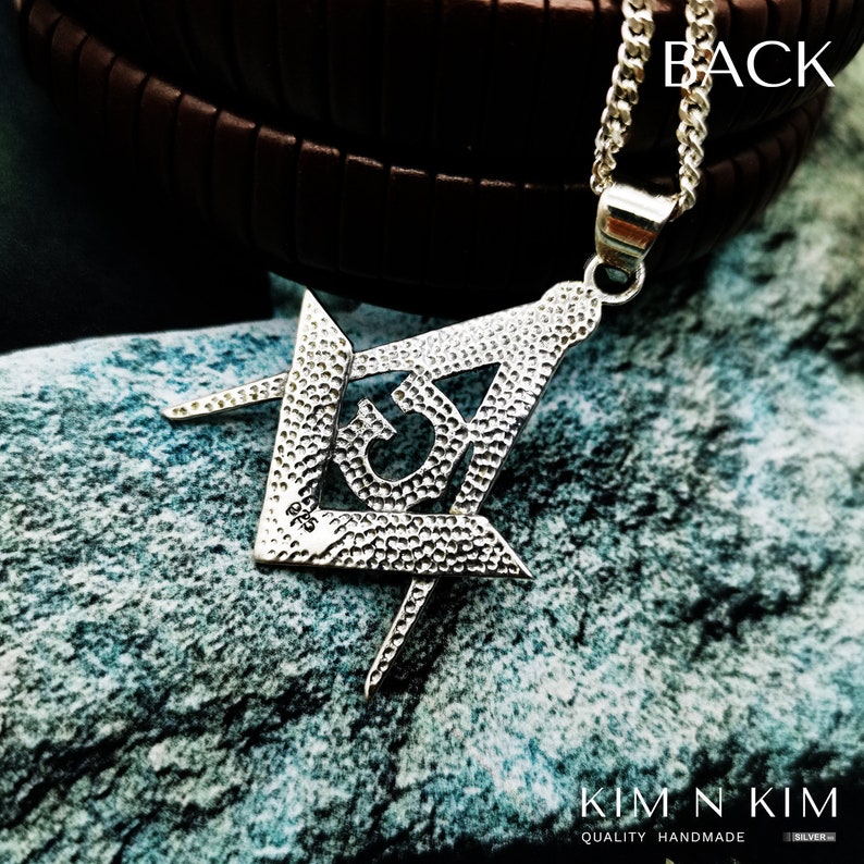May include: Silver Masonic pendant with a textured surface and a square and compass design. The pendant is on a silver chain.