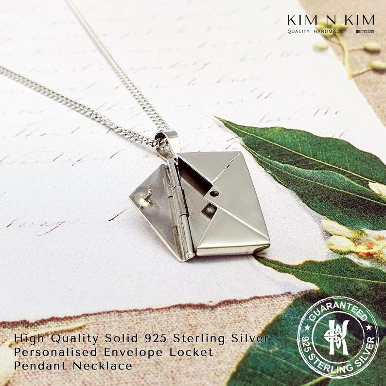 May include: A silver envelope locket pendant necklace. The locket is open and the inside is visible. The necklace is made of sterling silver and is guaranteed to be 925 sterling silver.