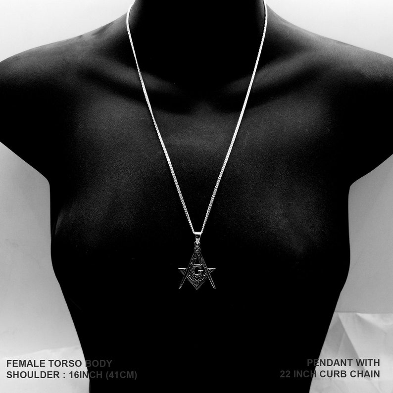 May include: A silver pendant necklace with a detailed compass and square design. The chain is 22 inches long and has a curb link style.