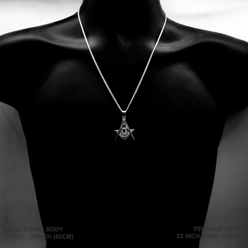 May include: Silver pendant necklace featuring a Masonic symbol with an all-seeing eye. The necklace is 22 inches long and has a curb chain.