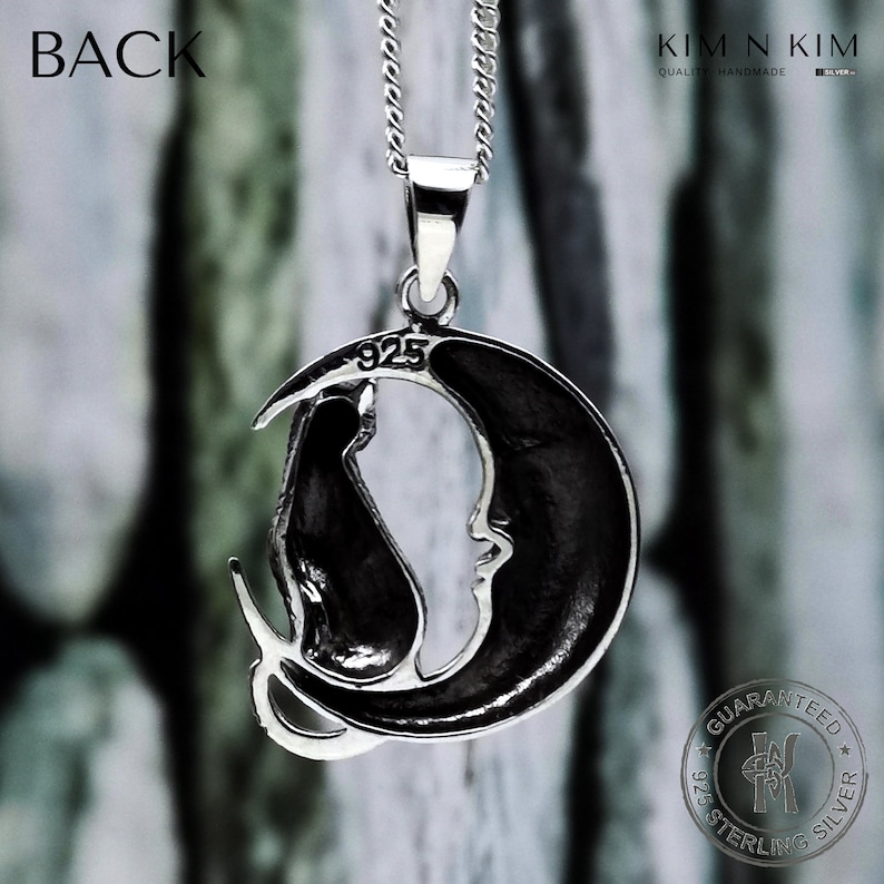 Puede incluir: Collar con colgante de plata de ley con un gato negro sobre una luna creciente. El colgante, marcado con "925", cuelga de una fina cadena de plata. La imagen muestra la palabra "BACK". La luna tiene una cara.