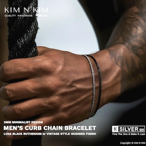 May include: Two minimalist curb chain bracelets, one black and one silver, are displayed on a wrist. The bracelets are 2mm in width and have a luxe black ruthenium or vintage style oxidized finish. The image includes the text "MEN'S CURB CHAIN BRACELET".