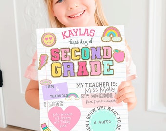 May include: A colorful sign held by a child, announcing "Kaylas first day of SECOND GRADE." The sign includes decorative elements like a rainbow, apple, and lightning bolt. Additional text includes "I am 6 years old" and "I love ice cream."