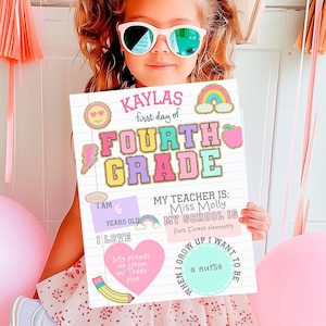 Puede incluir: Una niña sostiene un cartel que dice "Kaylas primer día de cuarto grado". El cartel está decorado con gráficos y texto coloridos. La niña lleva gafas de sol y un vestido rosa y blanco.