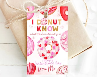 Può includere: Un'etichetta regalo bianca per San Valentino con ciambelle rosa e rosse decorate con cuori e codette. L'etichetta dice "I DONUT KNOW what I'd do without you!" e "Happy Valentine's Day from Mia".