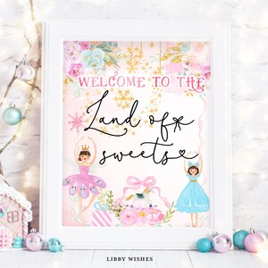 Puede incluir: Un cartel imprimible rosa y azul con el texto "Bienvenido a la tierra de los dulces" y dos figuras de bailarinas. El cartel tiene un diseño floral y detalles de purpurina dorada.