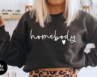 May include: Black sweatshirt with the text "homebody" in white cursive lettering and a small white heart.