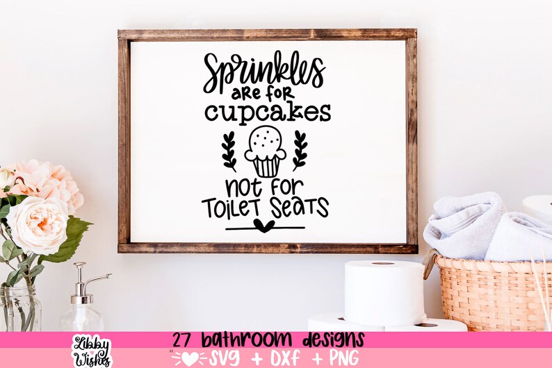 May include: A white sign with black text that reads "Sprinkles are for cupcakes not for toilet seats". The sign is framed in a brown wood frame. There is a cupcake illustration with a heart below the text.