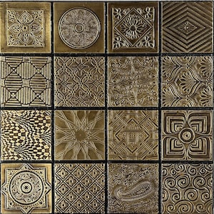 Könnte beinhalten: Ein Raster aus sechzehn quadratischen Fliesen mit geprägten metallisch goldenen Oberflächen und verschiedenen komplexen Mustern, darunter florale, geometrische, Paisley- und Wirbelmotive, getrennt durch dünne schwarze Linien.