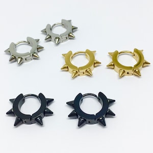 Op de afbeelding: Drie paar creolen met spikes. De oorbellen zijn zilver, goud en zwart.