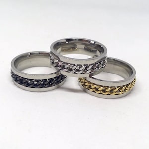 May include: Three stainless steel rings with a chain design. The rings are in black, silver, and gold.