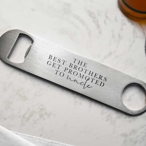 May include: Silver bottle opener with the text "The Best Brothers Get Promoted To Uncle" engraved on it.