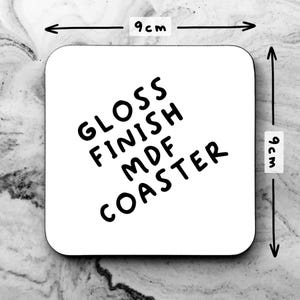 Puede incluir: Posavasos cuadrado blanco con texto negro que dice "Gloss Finish MDF Coaster". El posavasos mide 9 cm por 9 cm.