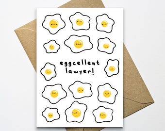 Op de afbeelding: Een witte kaart met een zwarte omtrek van een gebakken ei met een smiley in de dooier. De kaart heeft de tekst "eggcellent lawyer!" in zwart.