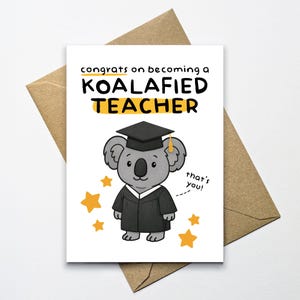 May include: A white greeting card featuring a cartoon koala in a graduation cap and gown. The card says "Congrats on becoming a KOALAfied TEACHER" with yellow stars and a brown envelope.