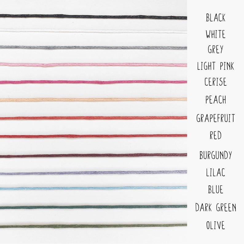 May include: A color chart showing 14 different colors of embroidery floss. The colors are: black, white, grey, light pink, cerise, peach, grapefruit, red, burgundy, lilac, blue, dark green, and olive.