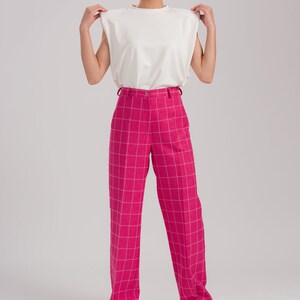 May include: A white sleeveless top with a pink and white plaid wide-leg pant.