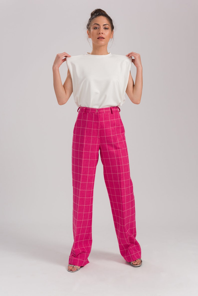 May include: A white sleeveless top with a pink and white plaid wide-leg pant.