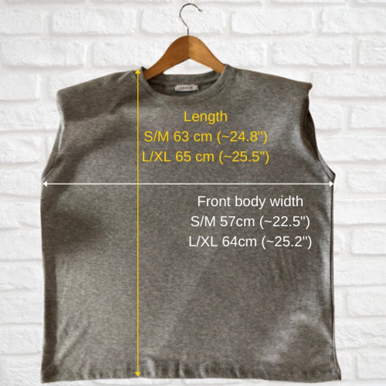 May include: Gray sleeveless shirt with a round neckline and a slightly oversized fit. The shirt has measurements for different sizes: S/M length 63 cm (24.8 inches), L/XL length 65 cm (25.5 inches), S/M front body width 57 cm (22.5 inches), L/XL front body width 64 cm (25.2 inches).