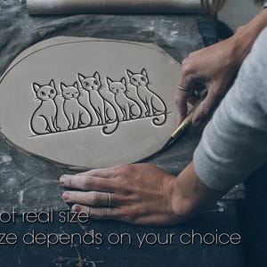 Könnte beinhalten: Ein hellgraues, ovales Tonstück mit einem geprägten Design von fünf stilisierten Katzen. Die Katzen sitzen nebeneinander. Der Text "Not real size" und "Size depends on your choice" befindet sich am unteren Rand des Bildes.