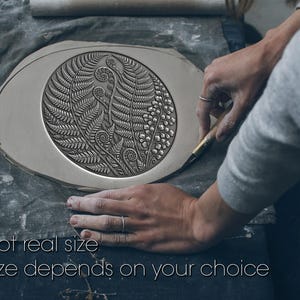 May include: A flat, oval-shaped piece of gray clay featuring a detailed, embossed fern leaf pattern within a central circle. The text "Not real size" and "Size depends on your choice" is printed in white at the bottom of the image.