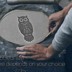 May include: A gray clay owl stamp with intricate floral and geometric patterns is being used to create a design. The text "Not real size" and "Size depends on your choice" is visible. The stamp is being used by a person.