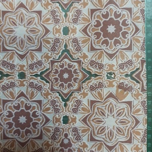 Könnte beinhalten: Ein Blatt Dekorpapier mit einem sich wiederholenden Muster aus braunen und weißen geometrischen Formen. Das Muster weist komplizierte Details und ein subtiles florales Motiv auf.