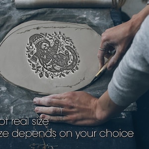 May include: A flat, circular piece of grey clay featuring an intricate embossed illustration of a dog wearing a winter hat and scarf, surrounded by forest elements like owls and pine trees. Text reads: Not real size. Size depends on your choice.