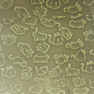 Peut inclure: Une feuille de papier blanc avec un motif répétitif de silhouettes de chats gris clair. Les chats sont dans diverses poses, y compris assis, dormant et debout.