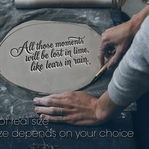 Könnte beinhalten: Ein hellgraues Tonstück mit dem Zitat "All those moments will be lost in time, like tears in rain." Der Text ist in den Ton gemeißelt. Der Satz "Not real size. Size depends on your choice" ist ebenfalls sichtbar.