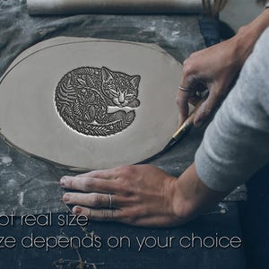 May include: A flat, circular piece of grey clay featuring a deeply embossed, intricate design of a curled-up cat covered in detailed fern and leaf patterns. The text "Not real size. Size depends on your choice" is printed at the bottom.