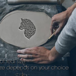 Könnte beinhalten: Ein hellgraues Tonstück mit einem Fuchskopf-Design, umgeben von floralen Mustern. Der Text "Not real size. Size depends on your choice" steht unten. Der Fuchskopf wird mit einem Werkzeug geschnitzt.