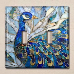 May include: A stained glass light switch cover featuring a peacock with blue, gold, and white feathers. The peacock's head is turned to the side, and its eye is visible.
