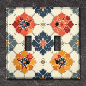 May include: A light switch cover with a decorative tile pattern featuring orange, red, blue, and white floral designs.