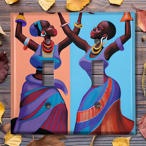 May include: Two women in colourful dresses dance with raised arms, one in a blue dress against a peach background, the other in a red dress against a blue background. The women are wearing jewellery and have elaborate hairstyles.