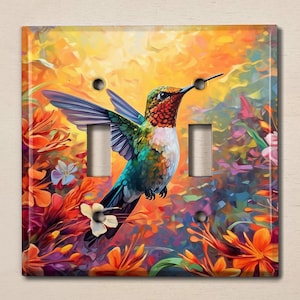 May include: A colorful light switch cover featuring a hummingbird in flight with a vibrant green, blue, and red plumage. The hummingbird is surrounded by a background of colorful flowers in shades of orange, pink, and purple.