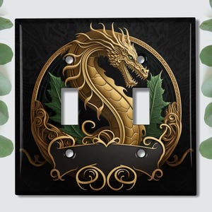 May include: A black light switch cover with a gold dragon design. The dragon is curled around a circle with green leaves and gold accents. The switch cover has a black background and a gold border.