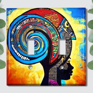 May include: A colorful light switch cover featuring an abstract portrait of a person with a blue and yellow patterned head covering. The background is a vibrant yellow and orange.