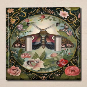 May include: A light switch cover with a decorative design featuring a large butterfly with intricate wings, surrounded by flowers and foliage in shades of green, pink, and white.