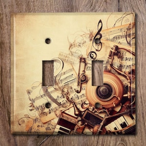 May include: A vintage-style light switch cover featuring a collage of musical notes, sheet music, and antique musical instruments. The background is a faded, cream-colored paper with a distressed texture.